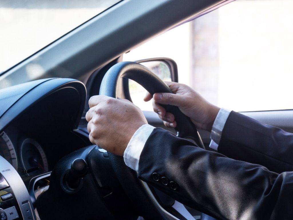 A businessman behind the wheel of a company car