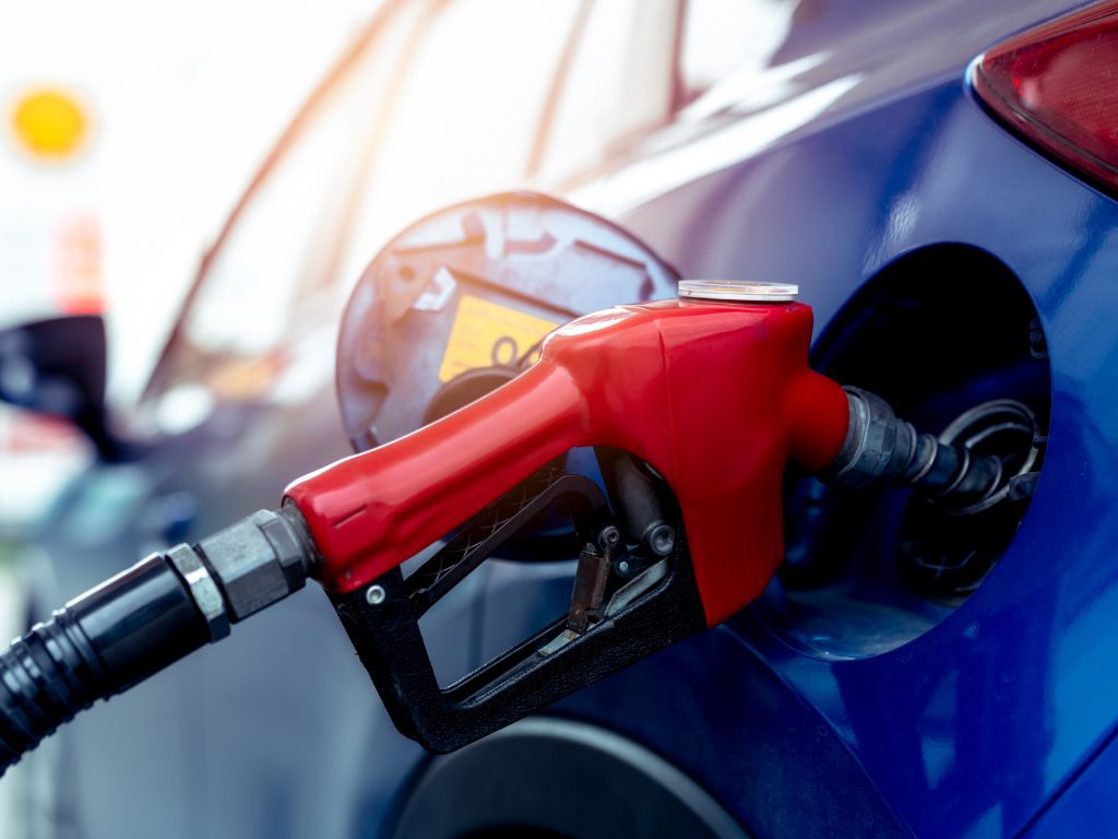 A petrol pump plugged into a car