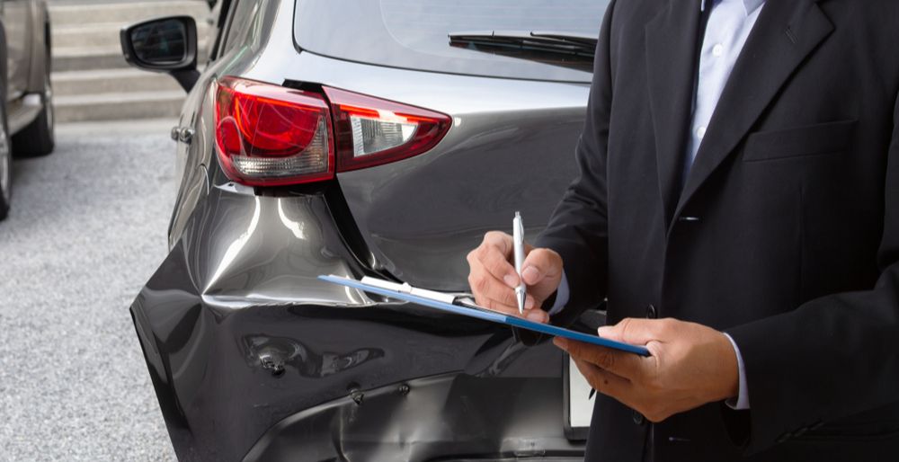 A businessman signs a vehicle lease contract