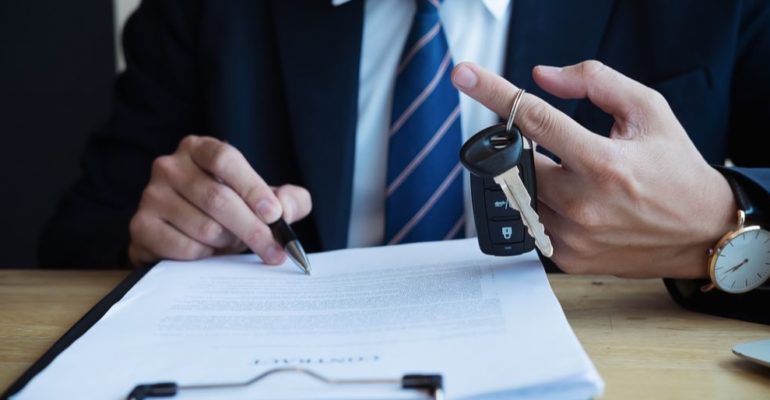 Signing a business car lease while holding car keys